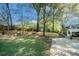 Expansive backyard with a patio, green lawn, and mature trees at 2210 Leafmore Dr, Decatur, GA 30033