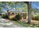 Charming brick home with a well-manicured lawn, mature trees, and a convenient carport, blending classic appeal with modern comfort at 2210 Leafmore Dr, Decatur, GA 30033