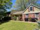 View of a charming two-story home with brick and siding, complemented by lush landscaping at 1150 Orchard Way, Roswell, GA 30075
