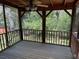 Relaxing screened porch with wood flooring and ceiling fan, offering a tranquil view of the lush greenery at 1150 Orchard Way, Roswell, GA 30075