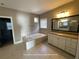Primary bathroom featuring double vanity, tile flooring, and a soaking tub at 13015 Fox Rd, Alpharetta, GA 30005