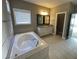 Bright bathroom features a soaking tub, large vanity with a mirror, and a separate toilet room at 13015 Fox Rd, Alpharetta, GA 30005