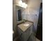 Bathroom featuring a gray countertop vanity with updated hardware, a mirror, and tiled flooring at 13015 Fox Rd, Alpharetta, GA 30005