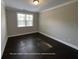 Spacious bedroom with dark wood floors and a bright window at 13015 Fox Rd, Alpharetta, GA 30005