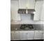 Kitchen features white cabinets, granite countertops, stainless steel hood, and subway tile backsplash at 13015 Fox Rd, Alpharetta, GA 30005