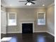 Neutral living room featuring a fireplace, dark floors, recessed lights, and bright windows at 13015 Fox Rd, Alpharetta, GA 30005