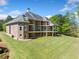 Expansive backyard with lush lawn and a large brick home featuring multiple balconies at 1660 Norris Landing Dr, Snellville, GA 30039