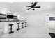 Entertainment bar with white cabinets, four stools, geometric backsplash, and sleek black countertop at 1660 Norris Landing Dr, Snellville, GA 30039
