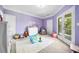 Bright, lavender-colored bedroom with toys, a white rug, and french doors leading to a balcony at 1660 Norris Landing Dr, Snellville, GA 30039