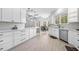 Bright, open kitchen with white cabinets, granite countertops, and modern appliances open to the dining and living room at 1660 Norris Landing Dr, Snellville, GA 30039