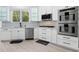 Well-lit kitchen with stainless steel appliances, white cabinets, and a stylish backsplash, perfect for cooking at 1660 Norris Landing Dr, Snellville, GA 30039