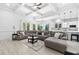 Open-concept living room features a large sectional couch, coffered ceiling, and a modern kitchen in the background at 1660 Norris Landing Dr, Snellville, GA 30039