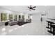 Inviting living room with white tile floors, comfortable seating, large windows, and a ceiling fan at 1660 Norris Landing Dr, Snellville, GA 30039