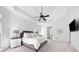 A bedroom featuring a trey ceiling, a ceiling fan, large windows, neutral colors, and view to the en-suite at 1660 Norris Landing Dr, Snellville, GA 30039