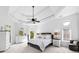 A primary bedroom showcases a trey ceiling, large windows, neutral colors, and elegant furnishings, for a peaceful retreat at 1660 Norris Landing Dr, Snellville, GA 30039