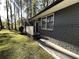 View of the side entrance to the home with brick foundation and lawn at 185 Maple Wood Dr, Lawrenceville, GA 30046