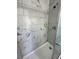 Shower featuring white tile with gray veining, complemented by modern fixtures and a clean design at 185 Maple Wood Dr, Lawrenceville, GA 30046