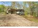 A tan home with a carport and screened-in porch is surrounded by beautiful mature trees at 5026 Daniel Mill Rd, Winston, GA 30187