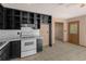 Kitchen features white appliances, white tile backsplash, and dark cabinets at 5026 Daniel Mill Rd, Winston, GA 30187