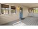 The covered porch has a blue door, gray flooring, and natural light at 5026 Daniel Mill Rd, Winston, GA 30187