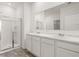 Modern bathroom featuring dual sinks, a large mirror, and walk-in shower at 604 Lobelia Way, Locust Grove, GA 30248