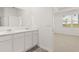 Bright bathroom showcasing a double vanity and a door to the bedroom at 604 Lobelia Way, Locust Grove, GA 30248