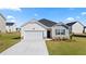 Charming single-story home featuring a two-car garage, manicured lawn, and a welcoming entrance at 604 Lobelia Way, Locust Grove, GA 30248