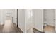 Hallway featuring wood-look floors and doorways that lead to a bedroom and a full bathroom at 604 Lobelia Way, Locust Grove, GA 30248