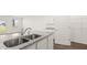 Modern kitchen island features stainless steel sink and granite countertops at 604 Lobelia Way, Locust Grove, GA 30248