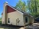 Exterior angle showing light siding, a red shingled roof, and mature trees at 1241 Baldridge Dr, Lawrenceville, GA 30044