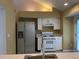 Well-lit kitchen with stainless steel refrigerator, white cabinetry, and modern appliances at 1241 Baldridge Dr, Lawrenceville, GA 30044