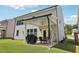 This backyard features a covered patio with string lights, a grill, and a manicured lawn at 160 Avery Landing Way, Canton, GA 30115