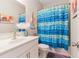 Charming bathroom featuring a white vanity, stylish mirror, and eye-catching blue ruffled shower curtain at 160 Avery Landing Way, Canton, GA 30115