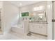 Bright bathroom features a soaking tub with marble surround, double sink vanity, and ample natural light at 160 Avery Landing Way, Canton, GA 30115