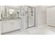 This bathroom includes a glass shower with marble surround, double sink vanity, and white marble flooring at 160 Avery Landing Way, Canton, GA 30115