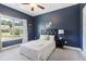 This navy bedroom has carpet flooring, ceiling fan, a bed, and a large window with a view at 160 Avery Landing Way, Canton, GA 30115
