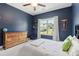 This navy bedroom has carpet flooring, ceiling fan, a bed, a dresser and a large window with a view at 160 Avery Landing Way, Canton, GA 30115