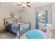 Cozy bedroom featuring a black metal bed frame, plush bedding, a rocking horse, and natural light from the window at 160 Avery Landing Way, Canton, GA 30115