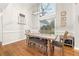 Dining room area with modern light fixture, hardwood floors, table with chairs and bench, and large window at 500 Katherines Cv, Mcdonough, GA 30253
