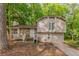 Two-story home featuring stone accents, complemented by a lush, wooded front yard at 5307 Jay Nw Way, Lilburn, GA 30047