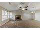 Carpeted living room with a stone fireplace, ceiling fan, and plenty of natural light at 5307 Jay Nw Way, Lilburn, GA 30047