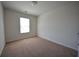 Comfortable bedroom featuring neutral carpeting, a window with natural light, and fresh paint at 5829 Taka Ln, Lithonia, GA 30038