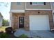 A townhome with brick siding, an attached one-car garage, and a walkway to the front door at 5829 Taka Ln, Lithonia, GA 30038