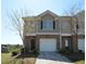 Charming townhome featuring a one-car garage and brick and beige siding with a well-maintained front yard at 5829 Taka Ln, Lithonia, GA 30038