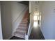 A hallway with wood-look flooring, carpeted stairs, and light-colored walls at 5829 Taka Ln, Lithonia, GA 30038