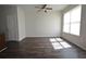 Bright living room with hardwood floors, ceiling fan, and natural light from large windows at 5829 Taka Ln, Lithonia, GA 30038