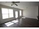 A living room with hardwood floors, a ceiling fan, and two large windows that let in plenty of natural light at 5829 Taka Ln, Lithonia, GA 30038
