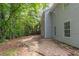 A backyard featuring trees and a home with light gray siding at 6205 Leverett Dr, Lithonia, GA 30038