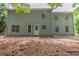 Back exterior of home features a door, multiple windows, and partial brick patio at 6205 Leverett Dr, Lithonia, GA 30038