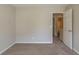 Neutral bedroom boasts plush carpeting and an open doorway to the bathroom at 6205 Leverett Dr, Lithonia, GA 30038